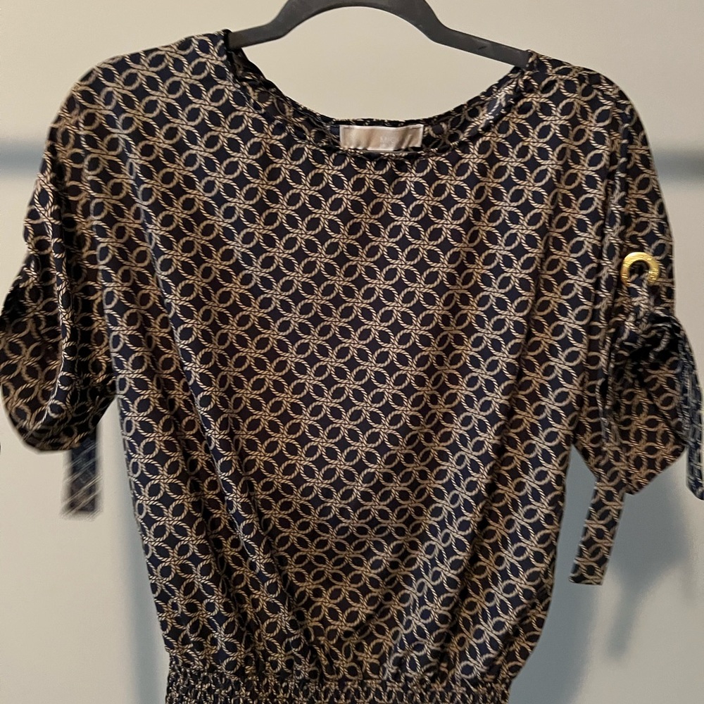 Black and gold top with embellished sleeve and fitted waist.